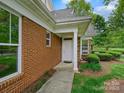 Charming front door and entryway with brick and stone exterior, plus manicured landscaping at 1910 Mezzo Ct, Matthews, NC 28105