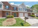 Charming brick townhome with green shutters, garage and well maintained landscaping on a sunny day at 2059 Lennox Square Rd, Charlotte, NC 28210
