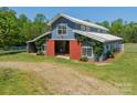 Picture of a large blue barn with white trim, red doors and a gravel path leading to the entrance at 228 Red Dog Dr, Mooresville, NC 28115
