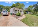 Home featuring a covered front porch and a well-maintained lawn and driveway at 2614 Thornton Rd, Charlotte, NC 28208
