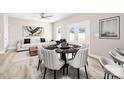 Modern dining area with round table, seating for six, and bright lighting, adjacent to backyard access and an airy living space at 3804 Freedom Dr, Charlotte, NC 28208