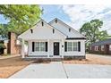 Inviting home with a covered porch, black door and shutters, and a freshly landscaped front yard at 417 Spring Sw St, Concord, NC 28025