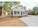Attractive house with a clean white facade, contrasting black accents, and a bright concrete driveway at 417 Spring Sw St, Concord, NC 28025