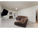 Spacious living room with fireplace, plush carpet, and brown reclining sofa for ultimate comfort and relaxation at 428 Whitewater Nw Way, Concord, NC 28027