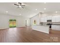 Open-concept living space with vaulted ceilings, wood floors, and a seamless transition to the kitchen at 5602 Skinny Dr, Charlotte, NC 28215
