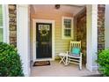 Inviting front porch with a welcoming wreath on the door and rocking chair at 8504 Sunset Hill Rd, Waxhaw, NC 28173