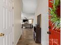 Bright foyer with a red door, brick accent wall, and a glimpse into the open-concept living area at 8604 Cedardale Ridge Ct, Charlotte, NC 28269