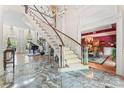 Grand foyer with marble floors, a sweeping staircase, and views into a dining room and living room with piano at 8934 Winged Bourne Dr, Charlotte, NC 28210