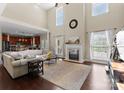 Bright living room boasts a soaring ceiling, fireplace, many windows, and wood floors at 1052 Perth Rd, Troutman, NC 28166