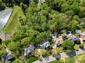 Aerial view showcasing neighborhood homes, mature trees and a pool in backyard at 10609 Oak Pond Cir, Charlotte, NC 28277