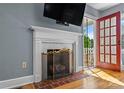 Close-up of the living room fireplace with a decorative screen and access to the porch at 1068 14Th Nw Ave, Hickory, NC 28601