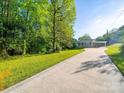 Inviting home featuring a long driveway leading to a classic brick facade and lush greenery at 1277 Rainbow Cir, Catawba, SC 29704