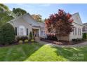 Charming brick home featuring manicured landscaping and a welcoming entrance, with a beautiful tree in the front yard at 1317 Waynewood Dr, Waxhaw, NC 28173