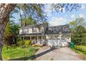 Home with covered front porch and attached garage is complemented by mature trees and a green lawn at 13843 Poppleton Ct, Charlotte, NC 28273