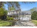 Traditional home with covered porch, attached two-car garage, and mature trees in a front yard at 13843 Poppleton Ct, Charlotte, NC 28273