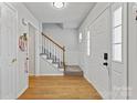 Bright foyer with hardwood floors, staircase with carpet runner, and paneled walls at 13843 Poppleton Ct, Charlotte, NC 28273
