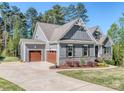 Gray home with an attached two car garage, driveway, stone accents and manicured landscaping at 143 Robinson Ridge Dr, Mooresville, NC 28117