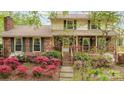 Inviting home with a brick facade, charming front porch, and colorful azalea bushes at 147 Spring Shore Rd, Statesville, NC 28677