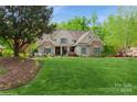 Charming home with lush front yard, stone and shingle exterior, and lovely landscaping at 1813 Wedowee Ct, Rock Hill, SC 29732