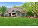 Charming home with lush front yard, stone and shingle exterior, and lovely landscaping at 1813 Wedowee Ct, Rock Hill, SC 29732