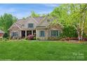 Charming home features a well-manicured lawn and inviting stone and shingle exterior with blue shutters at 1813 Wedowee Ct, Rock Hill, SC 29732