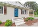 Inviting entrance with a blue front door, brick steps, and manicured landscaping at 212 Pine St, Rockwell, NC 28138