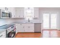 Modern kitchen featuring stainless steel appliances, granite countertops, and white cabinetry at 212 Pine St, Rockwell, NC 28138