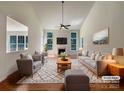 Bright living room features tall ceilings, gas fireplace, hardwood floors, and is virtually staged with stylish furniture at 2163 Woodstream Rd, Harrisburg, NC 28075