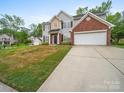 Two-story home featuring gray siding, brick accents, an attached two-car garage, and a concrete driveway at 253 Memory Ln, Rock Hill, SC 29732