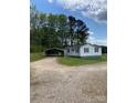 A cozy single-story home featuring a gravel driveway and carport on a bright, sunny day at 3514 Valley Dr, Chester, SC 29706