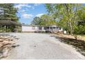 A cozy single-story house features a carport and screened porch, surrounded by a gravel driveway at 3536 Minnow Bridge Rd, Carlisle, SC 29031