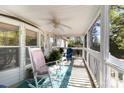Relaxing screened porch with rocking chairs, ceiling fan, and view of the surrounding greenery at 3536 Minnow Bridge Rd, Carlisle, SC 29031