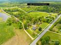 Aerial view of 29 acre property with trees, pond, road, and home highlighted by a white boundary line at 4896 Pageland Hwy, Lancaster, SC 29720
