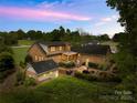 Aerial view of a brick home featuring a stone patio and well-maintained landscaping at twilight at 4896 Pageland Hwy, Lancaster, SC 29720