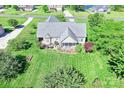 An aerial view showcases a well-manicured backyard with a screened porch and lush green lawn at 557 Luther Dr, Iron Station, NC 28080