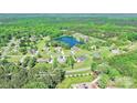 Aerial view of the property surrounded by trees, highlighting its location in a quiet neighborhood near a pond at 557 Luther Dr, Iron Station, NC 28080