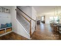 Open staircase with hardwood floors, carpeted stairs, and views of the adjacent living spaces at 7035 Butternut Oak Ter, Huntersville, NC 28078