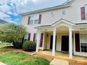 Welcoming townhouse featuring a cozy entrance with columns and well-maintained landscaping at 9615 Littleleaf Dr, Charlotte, NC 28215
