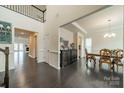 Open-concept dining room with dark wood floors, a wooden table, and views to other living spaces at 1005 Argentium Way, Waxhaw, NC 28173