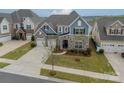 Aerial view of a charming home with a stone facade, a well-maintained lawn, and a paved driveway at 1005 Argentium Way, Waxhaw, NC 28173