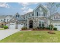 Beautiful two-story home featuring stone accents, a manicured lawn, and a two-car garage at 1005 Argentium Way, Waxhaw, NC 28173
