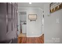 Welcoming entryway with hardwood floors leading to a laundry room with white cabinets at 1033 Southwest Dr, Davidson, NC 28036