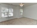 Bright bedroom with neutral carpet, two large windows, and ceiling fan at 1037 Hammond Dr, Matthews, NC 28104
