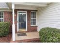 Inviting entryway with brick accents, decorative shrubbery, and clearly visible address numbers above the door at 11623 Black Maple Ave, Charlotte, NC 28269
