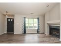 Bright and airy living room featuring a modern fireplace, wood floors, and natural light from large windows at 11623 Black Maple Ave, Charlotte, NC 28269
