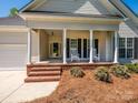 Inviting covered porch with rocking chairs and brick steps at 11778 Crossroads Pl, Concord, NC 28025