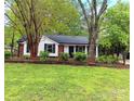Quaint single-story home with a well-manicured lawn and mature trees providing shade and curb appeal at 11817 Five Cedars Rd, Charlotte, NC 28226
