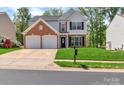 Charming two-story home with a brick and vinyl exterior, two-car garage, and well-manicured lawn at 1216 Stourbridge Lion Dr, Charlotte, NC 28213