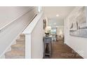 Inviting foyer with hardwood floors, staircase, and decorative console table at 14018 Wilson Mac Ln, Charlotte, NC 28278