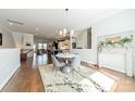 Open dining area flows into kitchen and living space with a modern chandelier and hardwood floors at 15133 Rocky Bluff Loop, Davidson, NC 28036